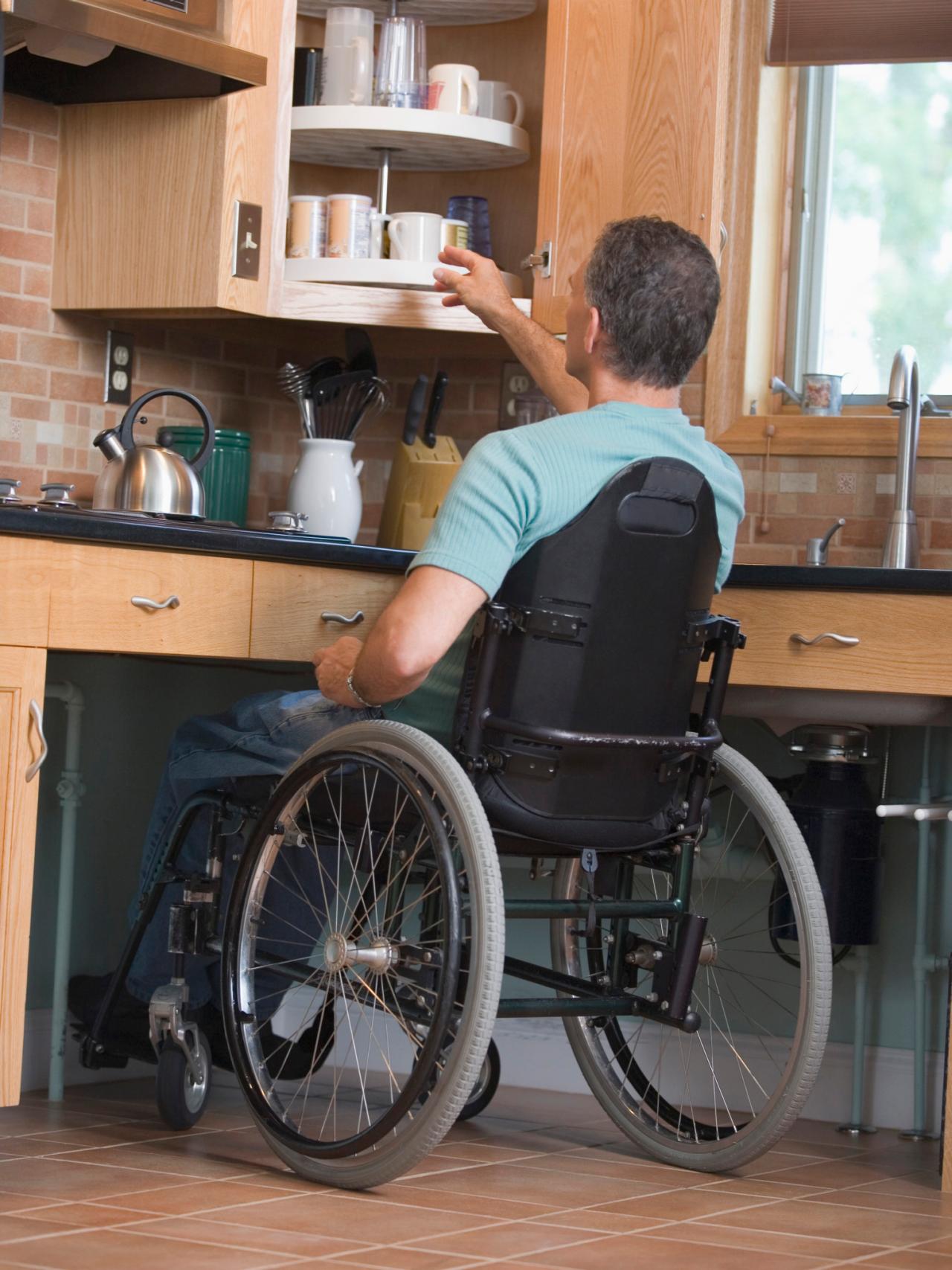 man reaching in a cupboard in his accessible kitchen